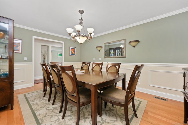 15 Oakledge Cir, Norwalk, CT 06854 - dining space with light wood finished floors, ornamental molding, a chandelier, and wainscoting