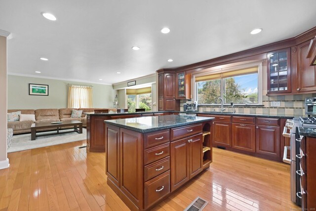 15 Oakledge Cir, Norwalk, CT 06854 - kitchen featuring stainless steel stove, ornamental molding, decorative backsplash, light wood-style floors, and open floor plan
