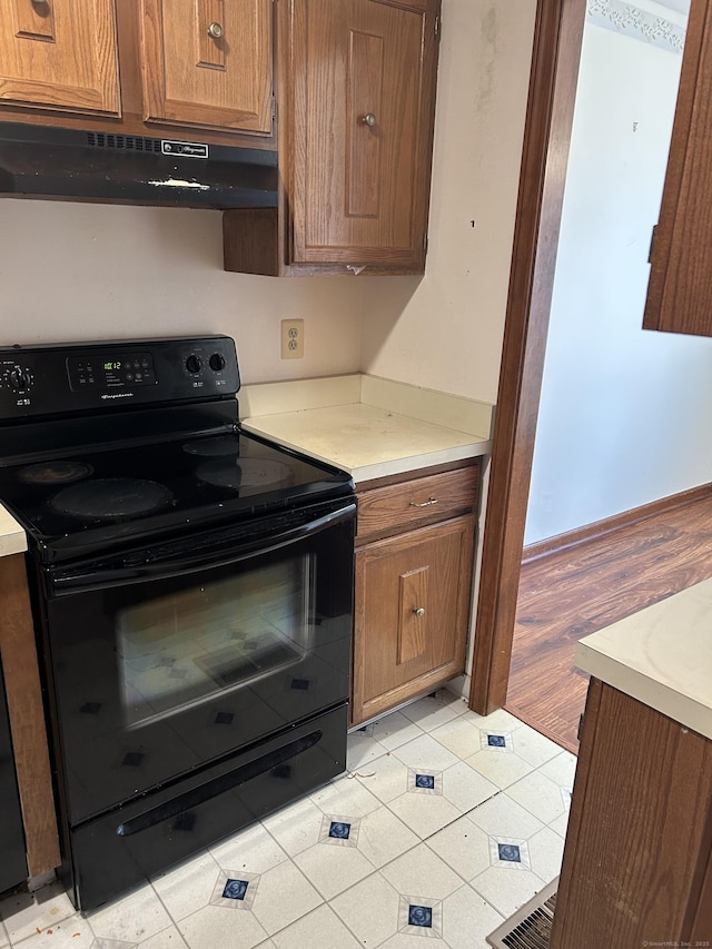 376 Cypress Rd Unit 376, Newington, CT 06111 - kitchen featuring black electric range, ventilation hood, light countertops, and brown cabinetry
