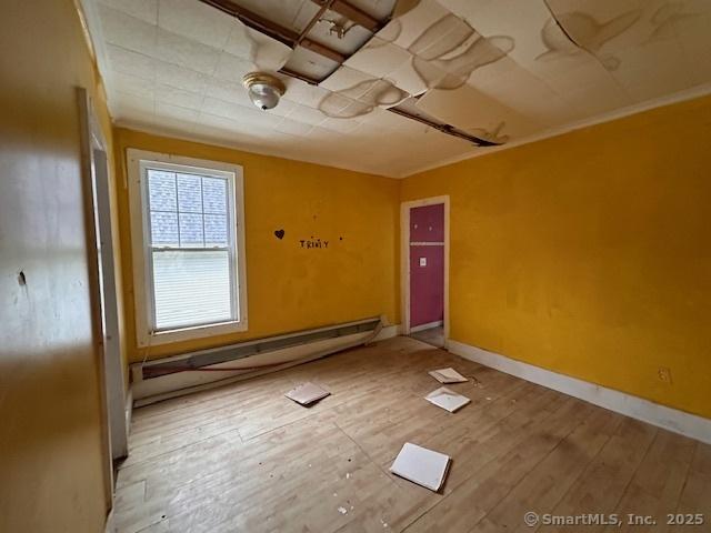 29 Division St, Norwich, CT 06360 - unfurnished room with wood finished floors and baseboard heating