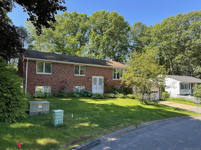 split foyer home featuring a chimney, driveway, and brick siding
