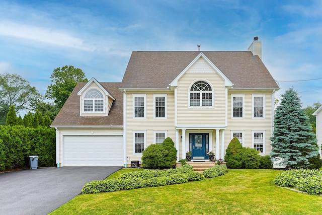 402 Jones Hill Rd, West Haven, CT 06516 - view of front of property with driveway, a front lawn, a chimney, and a shingled roof