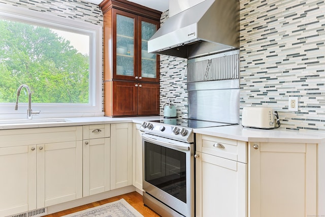 402 Jones Hill Rd, West Haven, CT 06516 - kitchen with electric range, range hood, backsplash, light countertops, and light wood-style flooring