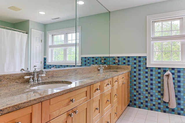 402 Jones Hill Rd, West Haven, CT 06516 - bathroom featuring tile walls, double vanity, a wainscoted wall, and tile patterned flooring
