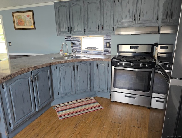 1290 N Rd Unit 15, Groton, CT 06340 - kitchen featuring stainless steel gas range, ventilation hood, a sink, wood finished floors, and a peninsula