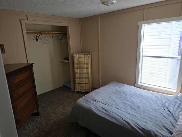 1290 N Rd Unit 15, Groton, CT 06340 - bedroom featuring a decorative wall, dark carpet, a textured ceiling, and a closet