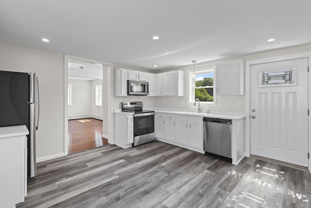 8 Wilson Ave, Waterford, CT 06375 - kitchen featuring appliances with stainless steel finishes, white cabinets, light countertops, light wood-style flooring, and recessed lighting