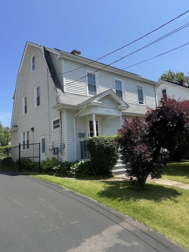 184 Palm St, Hartford, CT 06112 - view of property exterior featuring a chimney, a gambrel roof, and a lawn