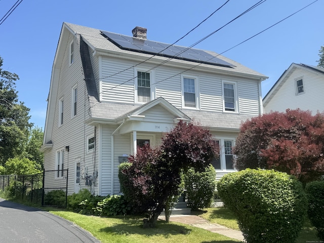 184 Palm St, Hartford, CT 06112 - view of front of home featuring roof mounted solar panels and a chimney