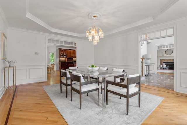 35 Hunting Ridge Rd, Easton, CT 06612 - dining area featuring a chandelier, light wood-style floors, crown molding, a decorative wall, and a raised ceiling