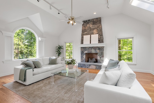 35 Hunting Ridge Rd, Easton, CT 06612 - living room featuring rail lighting, light wood finished floors, a ceiling fan, a stone fireplace, and high vaulted ceiling