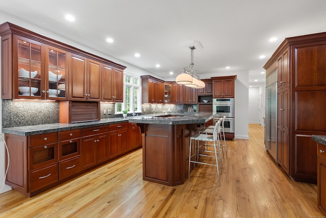 35 Hunting Ridge Rd, Easton, CT 06612 - kitchen with a kitchen bar, light wood-style floors, backsplash, glass insert cabinets, and pendant lighting