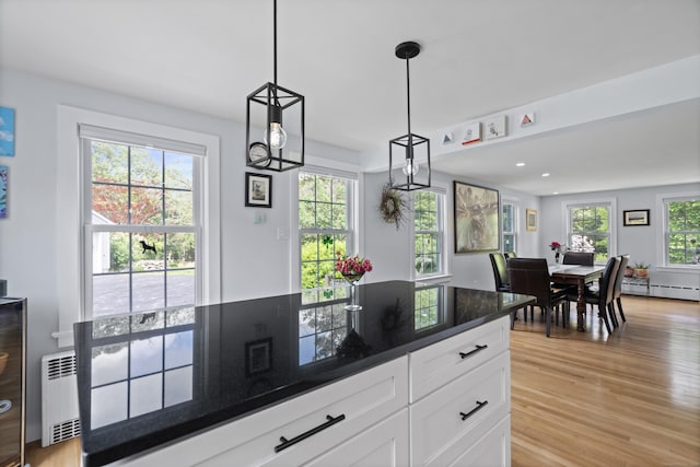 104 Quaker Farm Rd, Groton, CT 06355 - kitchen with radiator heating unit, a baseboard radiator, light wood-type flooring, white cabinetry, and hanging light fixtures