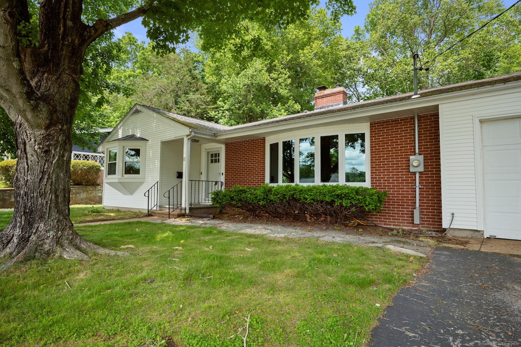 11 Deerbrook Rd, Norwich, CT 06360 - single story home with a chimney, a front yard, brick siding, and a garage