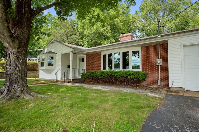11 Deerbrook Rd, Norwich, CT 06360 - single story home with a chimney, a front yard, brick siding, and a garage