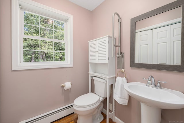 58 Snake Meadow Rd, Killingly, CT 06239 - half bath featuring baseboard heating, toilet, wood finished floors, a sink, and baseboards