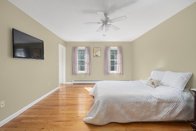 58 Snake Meadow Rd, Killingly, CT 06239 - bedroom with wood finished floors, baseboards, a baseboard radiator, ceiling fan, and a textured ceiling