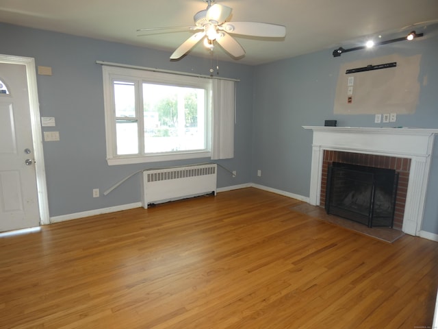 450 Thorme St, Bridgeport, CT 06606 - unfurnished living room with radiator, a ceiling fan, a fireplace, and baseboards
