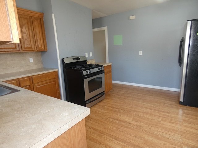 450 Thorme St, Bridgeport, CT 06606 - kitchen featuring appliances with stainless steel finishes, light countertops, light wood-style floors, baseboards, and tasteful backsplash