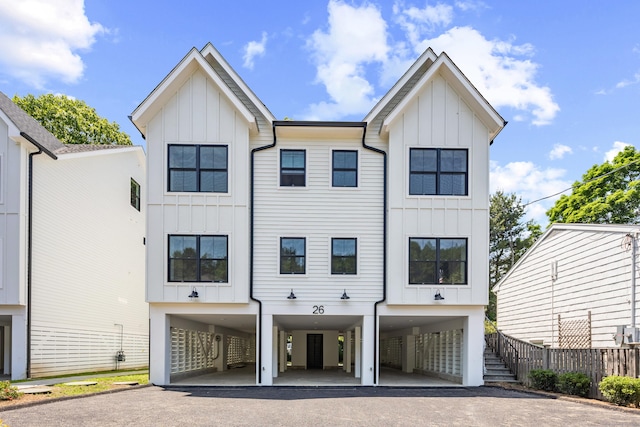 26 Homestead Ln Unit B, Greenwich, CT 06831 - view of front facade featuring board and batten siding, a carport, asphalt driveway, and stairway