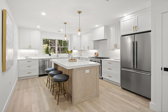26 Homestead Ln Unit B, Greenwich, CT 06831 - kitchen featuring premium appliances, custom exhaust hood, a sink, backsplash, and a kitchen bar