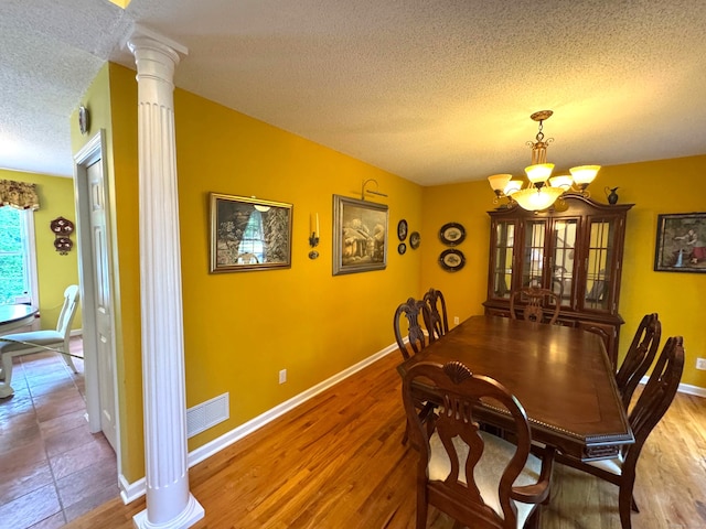 29 Swift St, Branford, CT 06405 - dining room featuring a textured ceiling, a chandelier, ornate columns, and wood finished floors