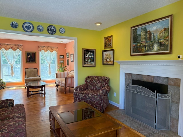 29 Swift St, Branford, CT 06405 - living area featuring a fireplace, wood finished floors, and a textured ceiling