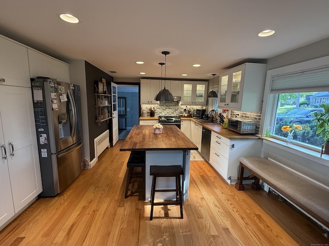 20 Marlin Rd, New Britain, CT 06053 - kitchen featuring wooden counters, appliances with stainless steel finishes, ventilation hood, backsplash, and glass insert cabinets
