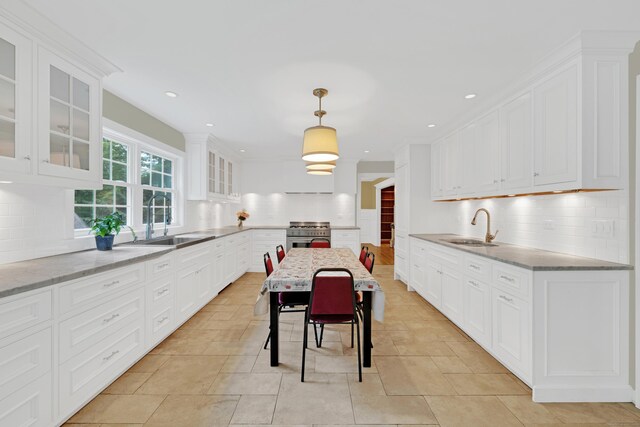 19 Maplecrest Dr, Danbury, CT 06811 - kitchen featuring white cabinets, backsplash, high end stove, glass insert cabinets, and hanging light fixtures