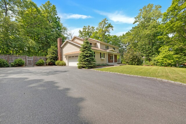 19 Maplecrest Dr, Danbury, CT 06811 - view of front facade with a garage, a chimney, and asphalt driveway