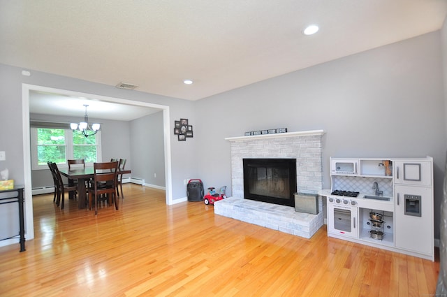 59 Settlers Knl, Newington, CT 06111 - living area featuring light wood finished floors, a chandelier, baseboard heating, a fireplace, and recessed lighting