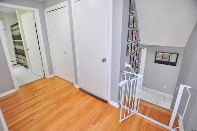 59 Settlers Knl, Newington, CT 06111 - hallway featuring wood finished floors, baseboard heating, baseboards, and stairway