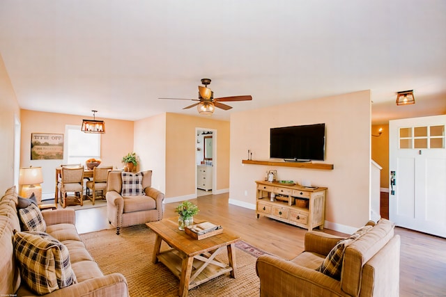 527 Highland Ave, Torrington, CT 06790 - living area with light wood-style flooring, a chandelier, a ceiling fan, and baseboards