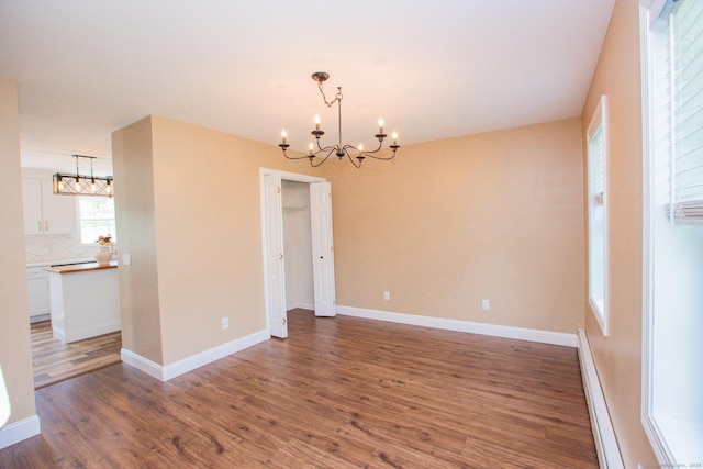 527 Highland Ave, Torrington, CT 06790 - spare room featuring a chandelier, wood finished floors, baseboard heating, and baseboards