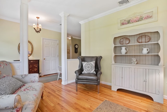 227 Meadow St, Shelton, CT 06484 - living area featuring decorative columns, light wood-style flooring, crown molding, a chandelier, and baseboards