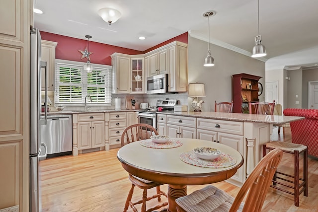 227 Meadow St, Shelton, CT 06484 - kitchen featuring appliances with stainless steel finishes, a sink, light wood-style flooring, a kitchen bar, and a peninsula