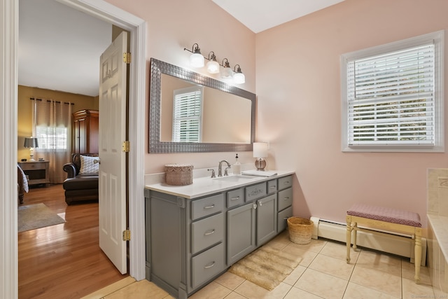 227 Meadow St, Shelton, CT 06484 - ensuite bathroom with vanity, a baseboard heating unit, and wood finished floors