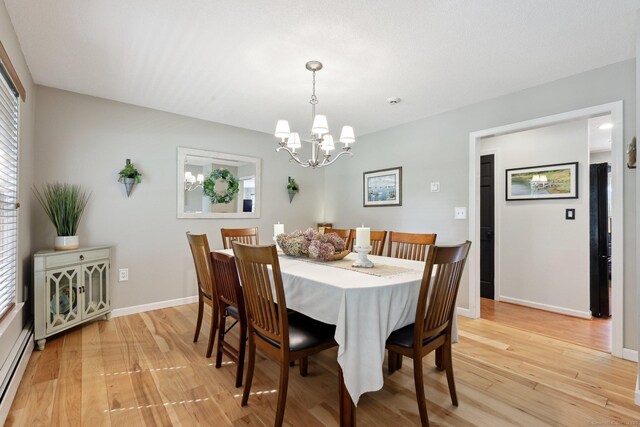 1 Spinnaker Rd, Waterford, CT 06385 - dining area featuring a baseboard radiator, light wood-style floors, a chandelier, and baseboards