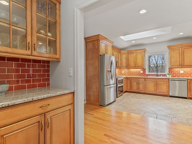 235 Lonetown Rd, Redding, CT 06896 - kitchen featuring stainless steel appliances, a skylight, decorative backsplash, glass insert cabinets, and recessed lighting