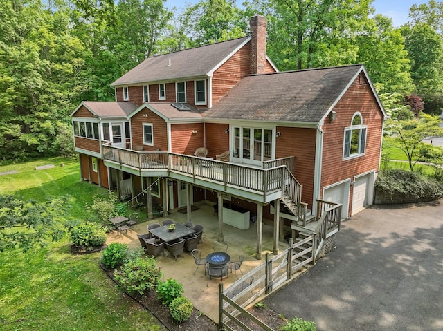 235 Lonetown Rd, Redding, CT 06896 - rear view of house with an outdoor fire pit, driveway, a deck, roof with shingles, and a chimney