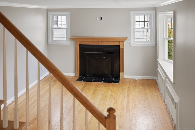73 Camp Ave, Newington, CT 06111 - unfurnished living room with hardwood / wood-style floors, ornamental molding, a tiled fireplace, healthy amount of natural light, and stairway