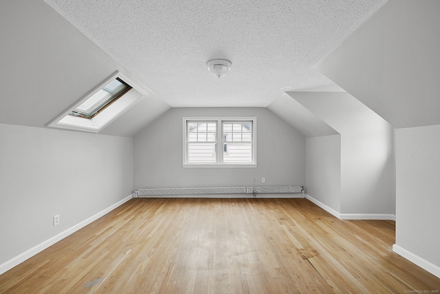 73 Camp Ave, Newington, CT 06111 - bonus room with wood finished floors, a skylight, lofted ceiling, a textured ceiling, and a baseboard heating unit