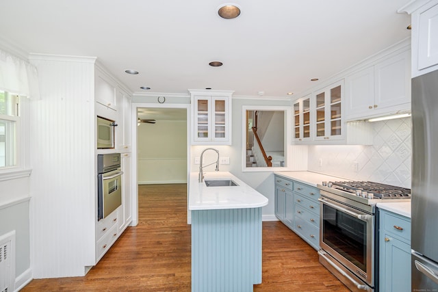 77 Crest Rd, Middlebury, CT 06762 - kitchen featuring appliances with stainless steel finishes, a sink, glass insert cabinets, tasteful backsplash, and wood finished floors