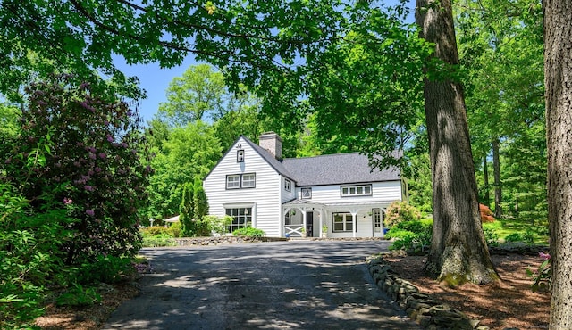 77 Crest Rd, Middlebury, CT 06762 - view of front facade with a chimney, driveway, and a shingled roof