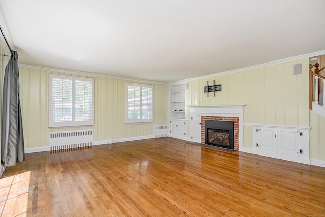 77 Crest Rd, Middlebury, CT 06762 - unfurnished living room with radiator, wood finished floors, a brick fireplace, and crown molding