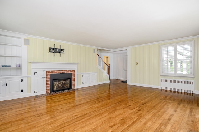 77 Crest Rd, Middlebury, CT 06762 - unfurnished living room with radiator, stairs, crown molding, wood finished floors, and a fireplace