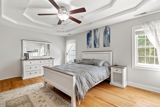 55 Perry Ln, Stratford, CT 06614 - bedroom with a raised ceiling, multiple windows, light wood-type flooring, and a ceiling fan