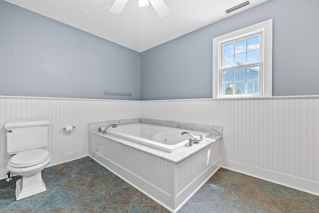 55 Perry Ln, Stratford, CT 06614 - full bathroom featuring a jetted tub, a wainscoted wall, toilet, ceiling fan, and baseboards