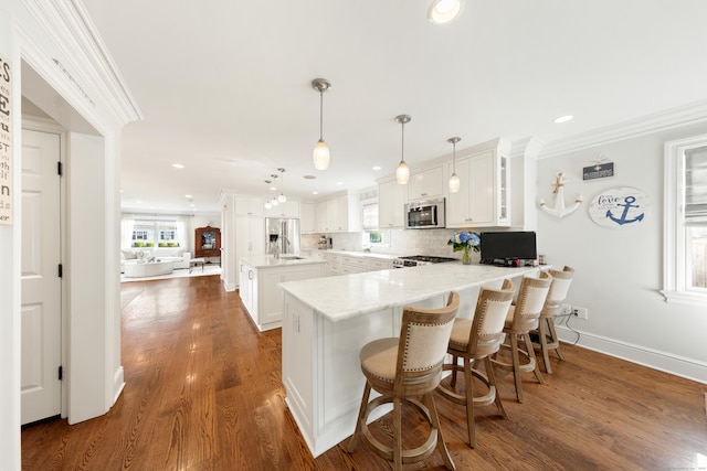 334 W Ave, Darien, CT 06820 - kitchen with appliances with stainless steel finishes, ornamental molding, a peninsula, decorative backsplash, and recessed lighting