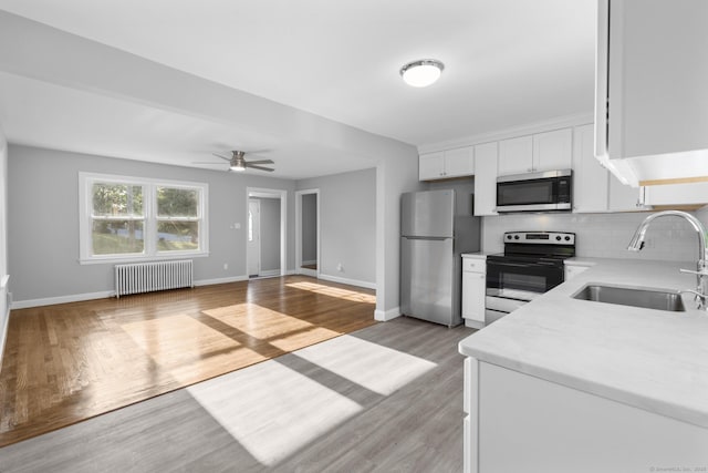 37 View St, East Haven, CT 06512 - kitchen with radiator, stainless steel appliances, a sink, light countertops, and decorative backsplash